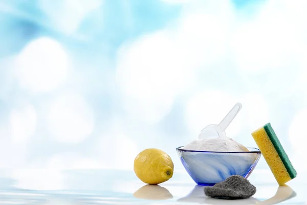 Household cleaning with baking soda, lemon and sponge isolated on white background.