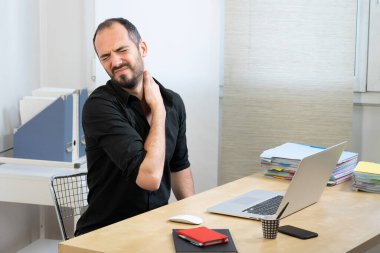 A man at his desk with neck pain.