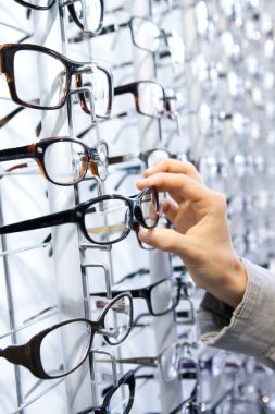 Woman choosing glasses at an optician.