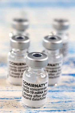 5 vaccine vials on blue background