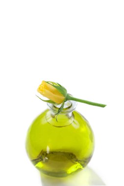 Essential oils bottles with fresh yellow roses, close soft light. Botanical treatment aromatherapy