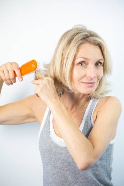 Woman looking at her split ends.