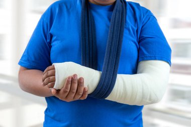 Young mixed-race boy with his arm plastered