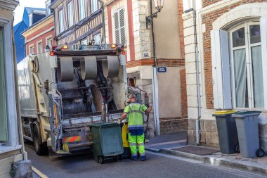 Report of a truck collecting household waste in a small street.