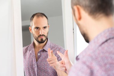 A man looking in a mirror to give him self-confidence.