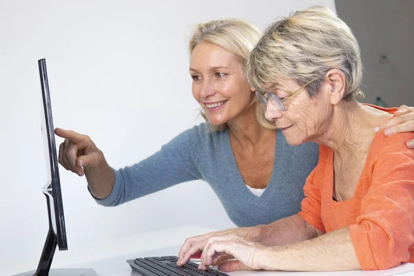 Woman Her Fifties Helping Elderly Woman Use Computer — Zdjęcie stockowe