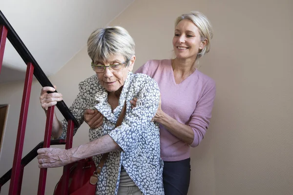 Elderly Woman Being Helped Another Woman Climb Stairs — Stock Fotó