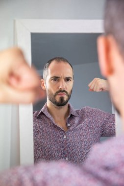 A man looking in a mirror to give him self-confidence.