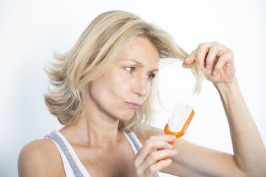 Woman looking at her split ends.