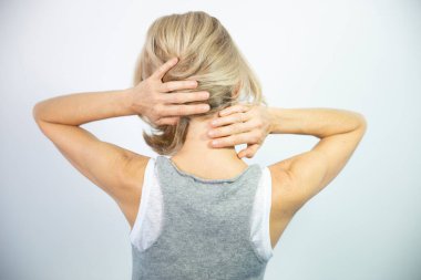 A woman feeling pain in her neck.