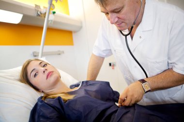 Un mdecin verrifie les constantes d'une patiente avant son entr au bloc opratoire. 