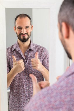 A man looking in a mirror to give him self-confidence.