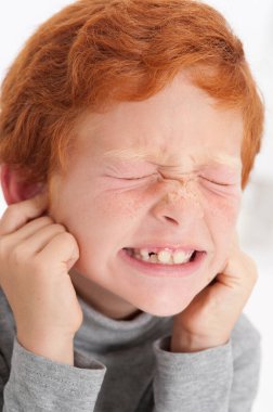 Boy sticking fingers in his ears.