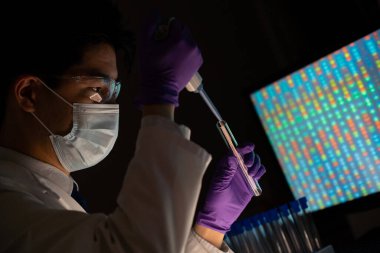 Male researcher in front of genome screens.