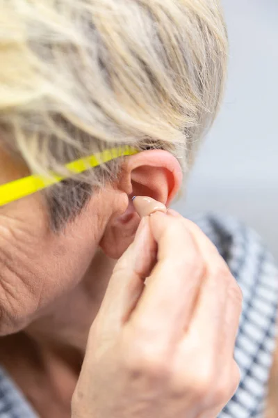 Woman Placing Hearing Aid Her Ear — Zdjęcie stockowe