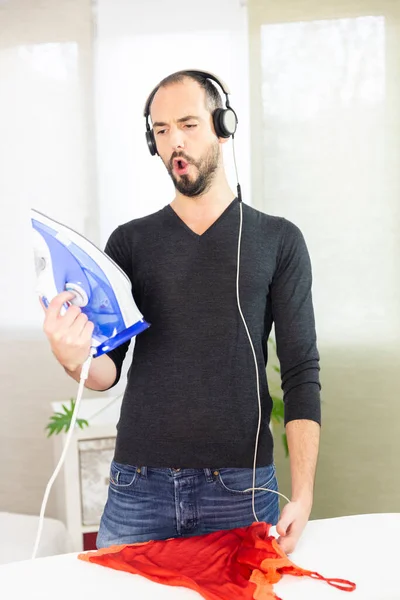 Man Ironing While Listening Music Singing — Stockfoto