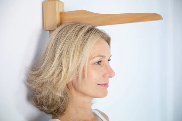 Woman Measuring Herself Height Measuring Rod — Stockfoto