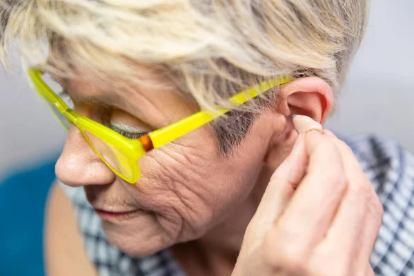 Woman Placing Hearing Aid Her Ear — 스톡 사진