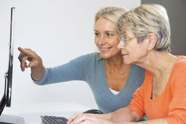 Woman Her Fifties Helping Elderly Woman Use Computer — Zdjęcie stockowe