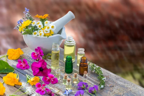 Essential oil and perfume from medicinal plant in mortar surrounded by petals
