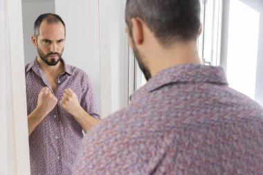 A man looking in a mirror to give him self-confidence.