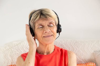 A woman expressing joy while listening to music in headphones.