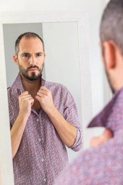 A man looking in a mirror to give him self-confidence.
