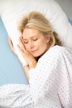 Yatağında uyuyan bir kadın.