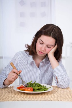Teenager with a plate of vegetables.