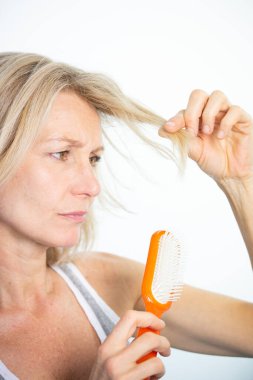 Woman looking at her split ends.