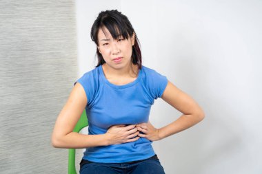 Asian woman having heartburn