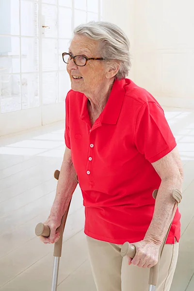 Mulher Sênior Andando Com Muletas — Fotografia de Stock