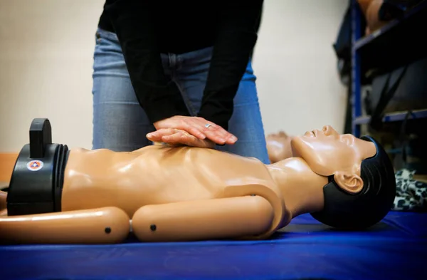 First aid training: learning cardiac massage on a mannequin.