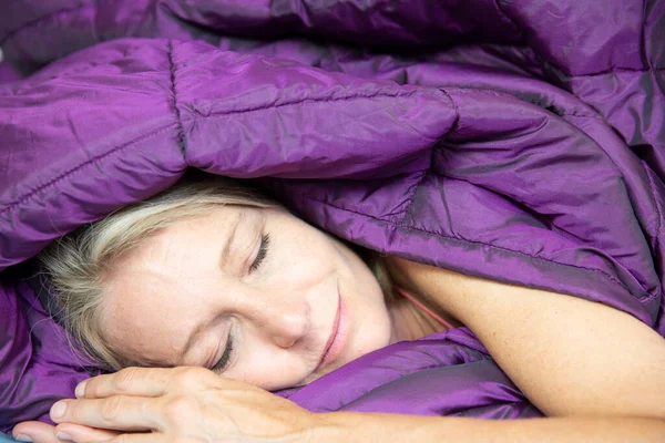 Woman sleeping in a duvet.