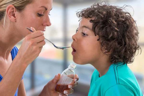 Mother Giving Her Son Spoon Medicine — Stockfoto