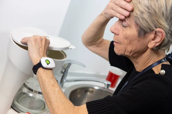 Elderly woman with a medical alert system around her wrist.