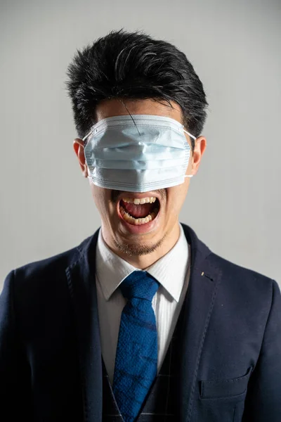 Screaming man wearing a mask over his eyes