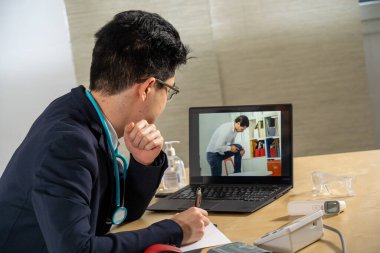 Doctor in remote consultation with 30 year old patient with knee pain