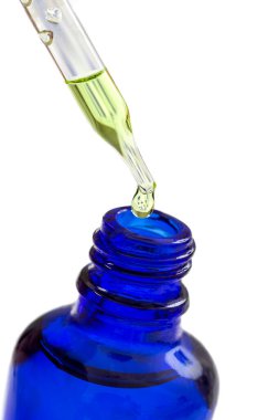 Essential oil Skin care and alternative medicine.Essential oil dropping from pipette to the bottle.