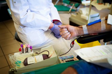 Donate blood at a blood collection facility.