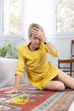 An elderly woman on her floor having fallen.