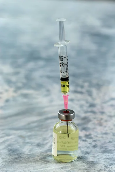 Vaccine injection : Close-up of a syringe taking vaccine in a bottle in a clinic.