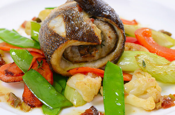 Sea bass fillet with spring vegetables and olive sauce