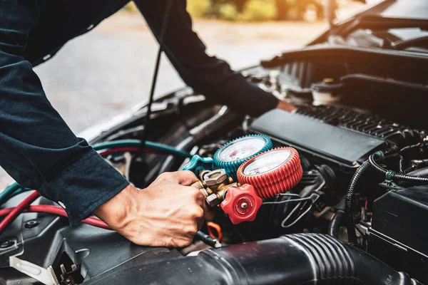 自動車整備士の手を閉じて車のエアコンを充填するための測定マニホールドゲージを使用することです 修理サービスと自動車保険の修理とチェックの概念 — ストック写真