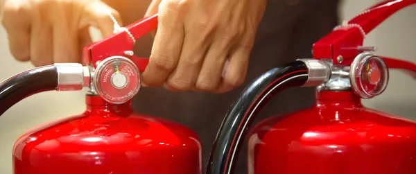 Brandweerman Trekt Veiligheidsspeld Aan Het Handvat Van Rode Brandblussers Tank Rechtenvrije Stockafbeeldingen