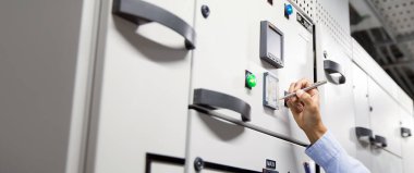 Elektrik mühendisliğinin yakın çekim kolu, ana güç dağıtım panosunda bakım için devre kesici ve kablo kablo sistemindeki elektriği kontrol etmek için ölçüm aracı kullanıyor..