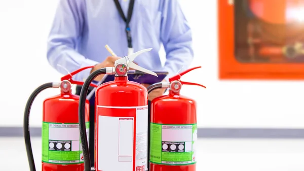 火災工学は 建物の保護の概念で消火器タンクの圧力計レベルをチェックし 緊急時と安全救助と火災訓練のための防止 ロイヤリティフリーのストック画像