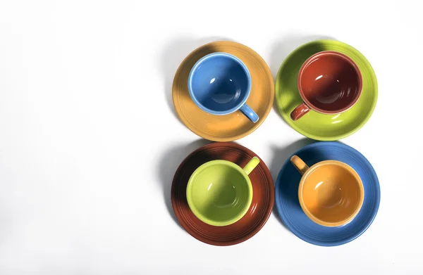 Набор из четырех красочных чашек и тарелок — стоковое фото