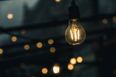 Bir kafe ya da restoranın sokak terasında aydınlanma. Ampuller. Bulutlu hava.