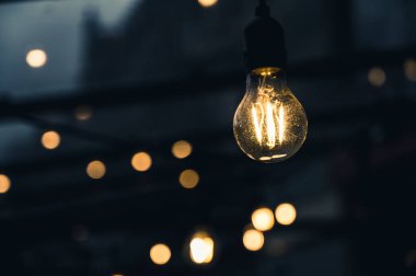 Bir kafe ya da restoranın sokak terasında aydınlanma. Ampuller. Bulutlu hava.